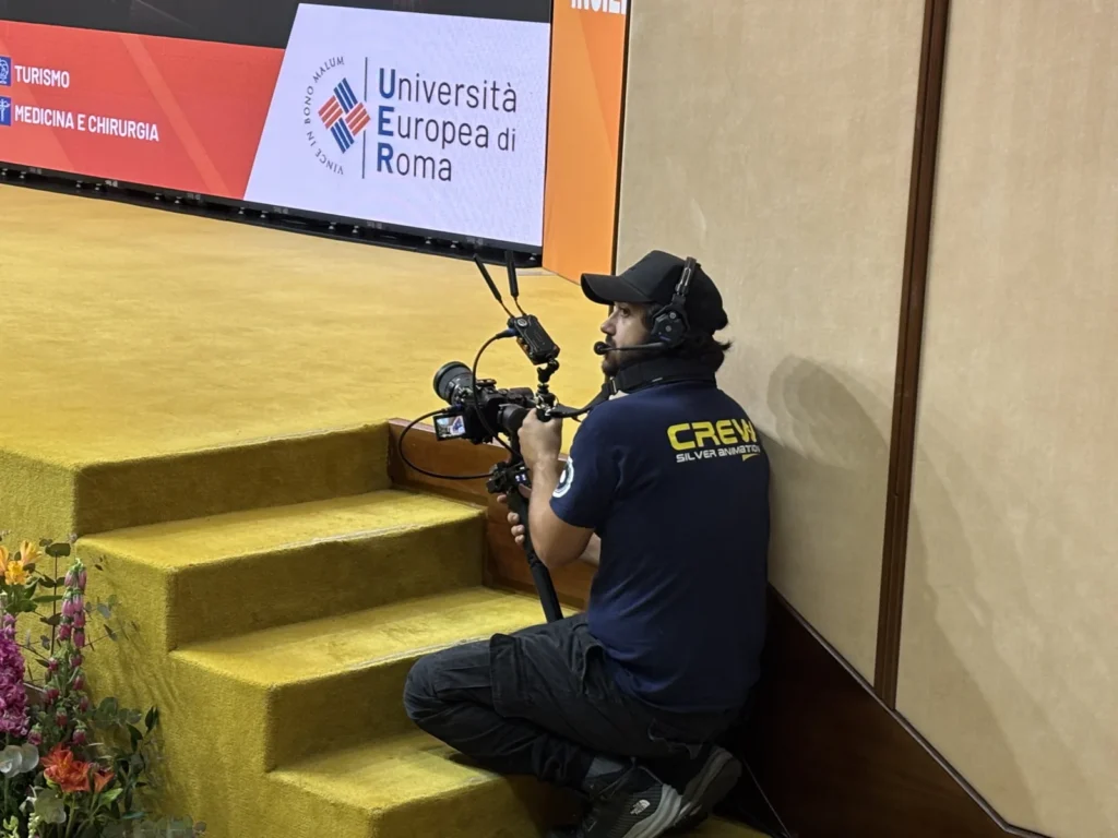 Operatore video durante ripresa live per diretta streaming evento corporate